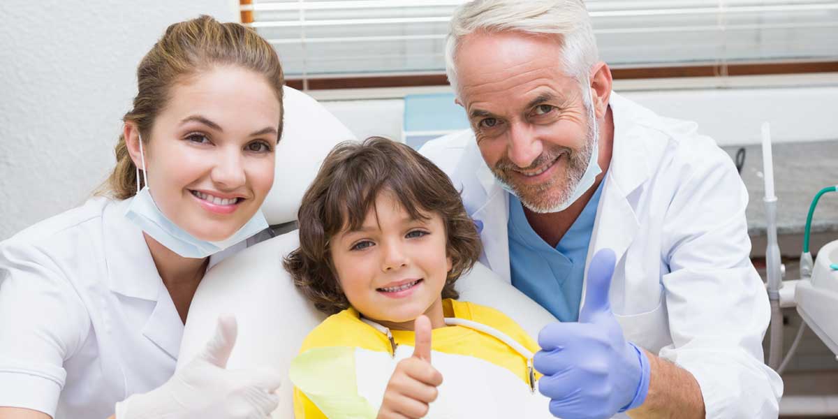 Two Dentists and Child Patient in Clinic